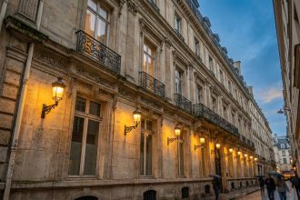Façade haussmannienne mise en valeur par un éclairage architectural soigné à Paris au crépuscule