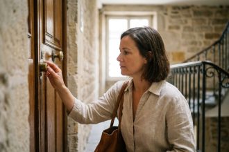 Femme vérifiant la serrure de son appartement lyonnais avant de partir en vacances